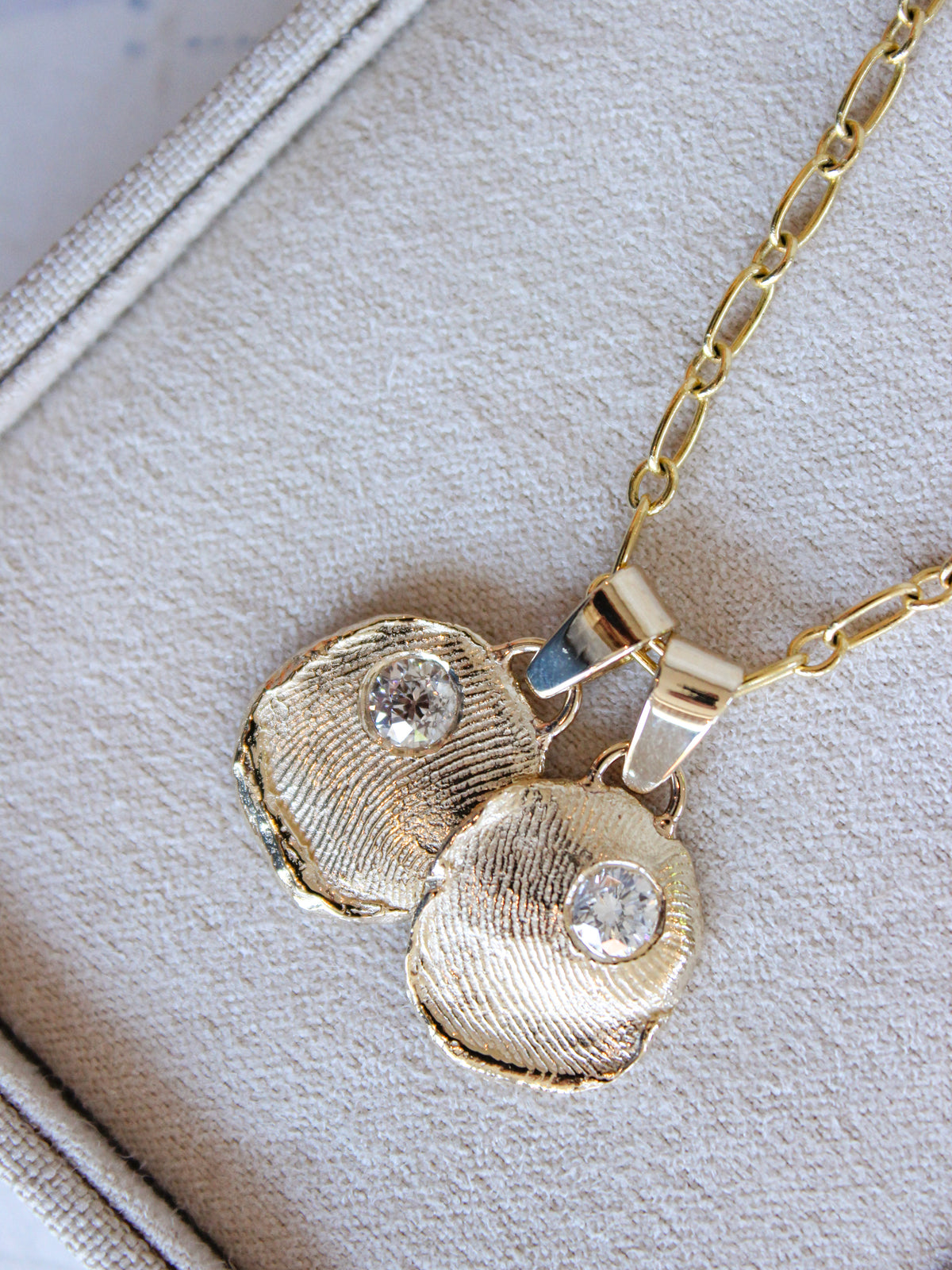 Custom heirloom fingerprint pendant with hand-carved gold texture and diamond detail.